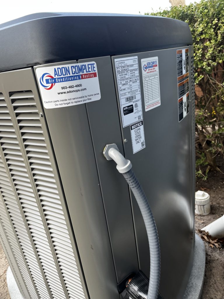 Outdoor heat pump with Adon sticker on it.