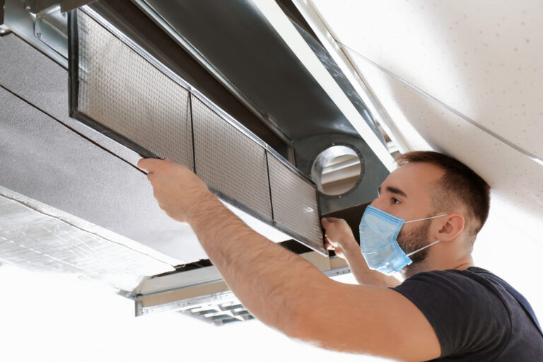 Adon technician inspecting leaking air duct.