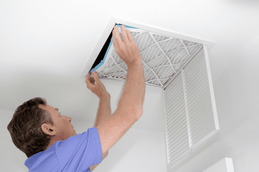 Adon HVAC technician changing air filter in McKinley, TX, house.