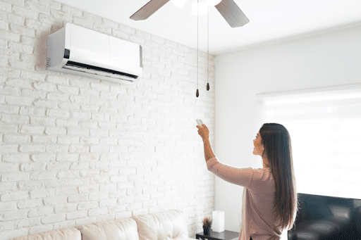 A woman using a remote to control a ductless mini-split system in a McKinney, TX home.